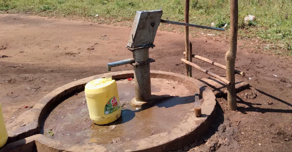 A handpump with a yellow container placed nearby in Wassa East, Ghana. The setting appears to be a rural area with access to groundwater. Heavy Metals Water Wassa East.