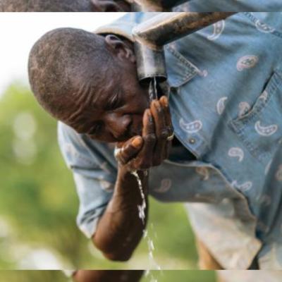 A man drinks water from a hand pump. Photo credit: Nana Acquah for Winrock International