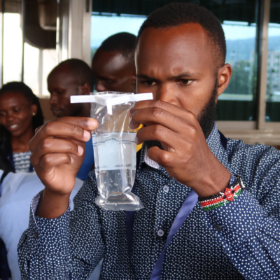 A man holding a plastic container filled with water.
